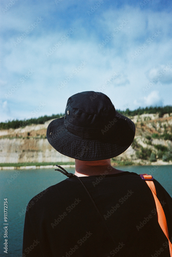 Young man looking out over a lake (blurred background) Young man looking out over a lake (blurred background)