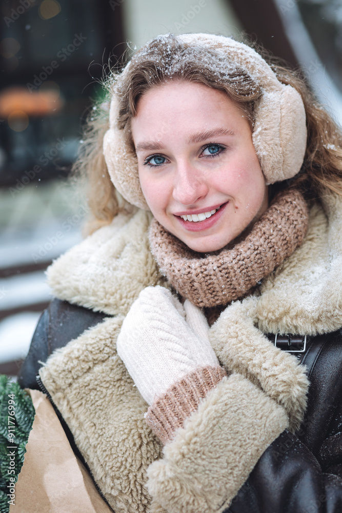 Beautiful young woman in winter in the snowy forest wearing warm clothes. Smiling, feeling happy walking under the snowflakes Beautiful young woman in winter in the snowy forest wearing warm clothes. Smiling, feeling happy walking under the snowflakes