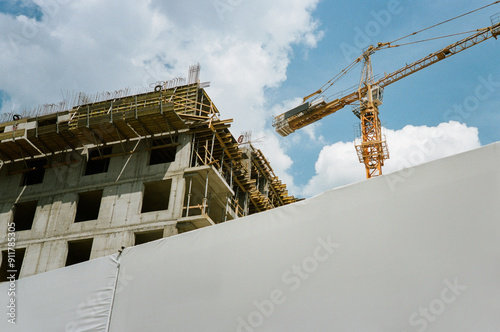 Construction crane near building against the blue sky