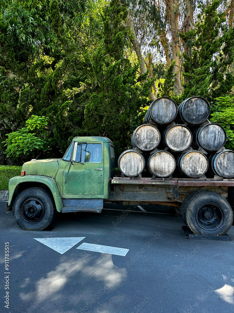 Fototapeta premium vintage car at winery with wine barrels, sunny day, winery visit, wine barrels