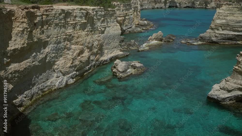 A stunning view of the clear turquoise waters and rugged cliffs in torre dell'orso, salento, puglia, italy on a beautiful sunny day A stunning view of the clear turquoise waters and rugged cliffs in torre dell'orso, salento, puglia, italy on a beautiful sunny day