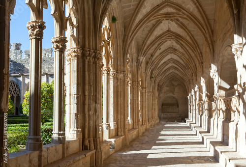 Gothic vaulted arcade with decorated ogival openings in cloister of Monastery of Santa Maria de Santes Creus, Aiguamurcia, Spain.. photo