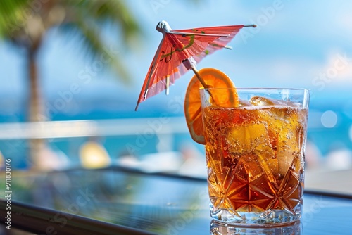 Cocktail with ice and umbrella on the background of the sea. Refreshing drink with ice and straw on the background of sea.
 photo