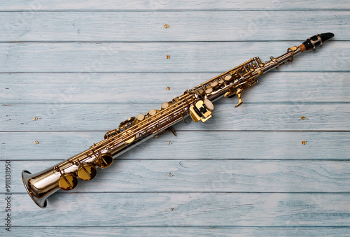 Soprano saxophone on beautiful blue wooden background.