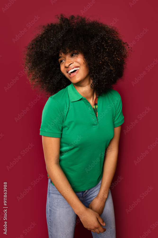 Young black woman laughing in green shirt against red background Young black woman laughing in green shirt against red background