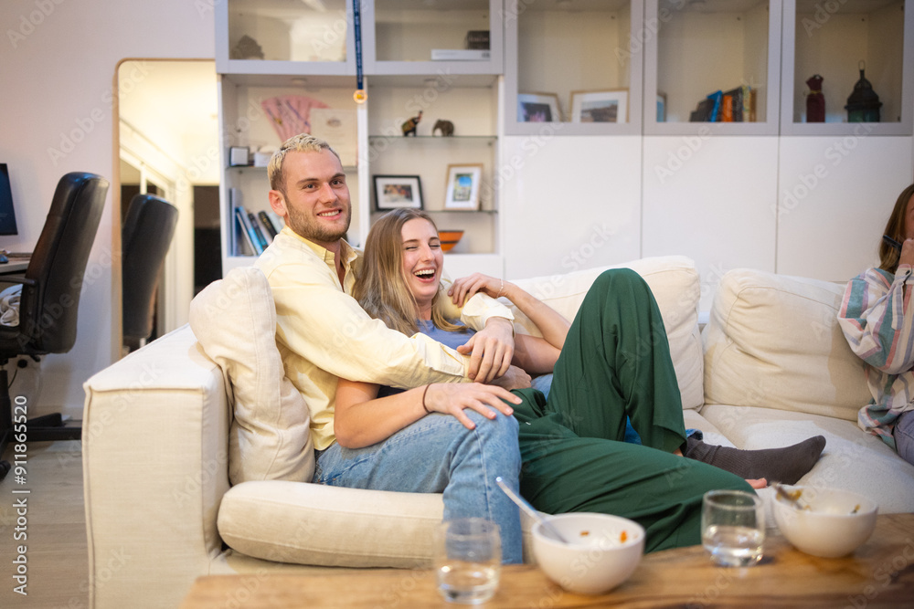 Couple watching a movie embracing on sofa Couple watching a movie embracing on sofa