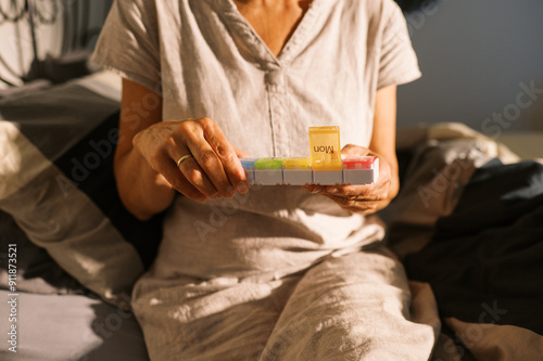 woman taking supplement pill at home in bedroom