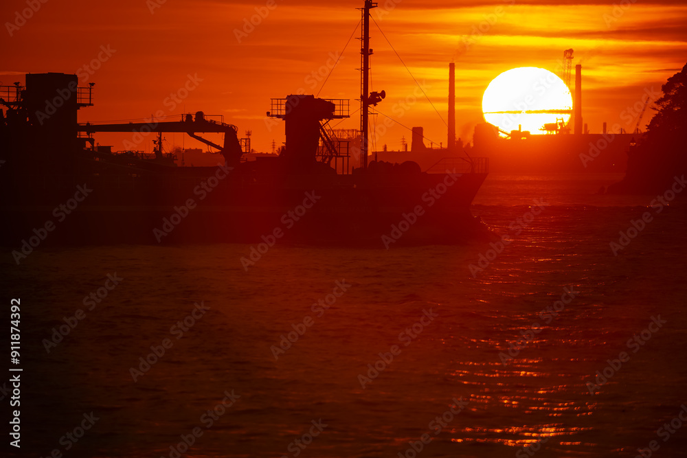 Obraz premium 関門海峡の日没と横切ろうと進む船影20240720-2