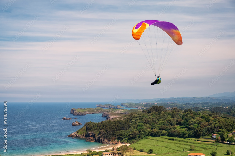 A paraglider flying over the coast A paraglider flying over the coast