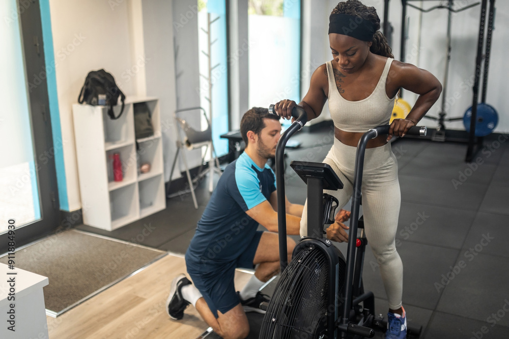 black woman doing sports in the gym with her personal trainer black woman doing sports in the gym with her personal trainer