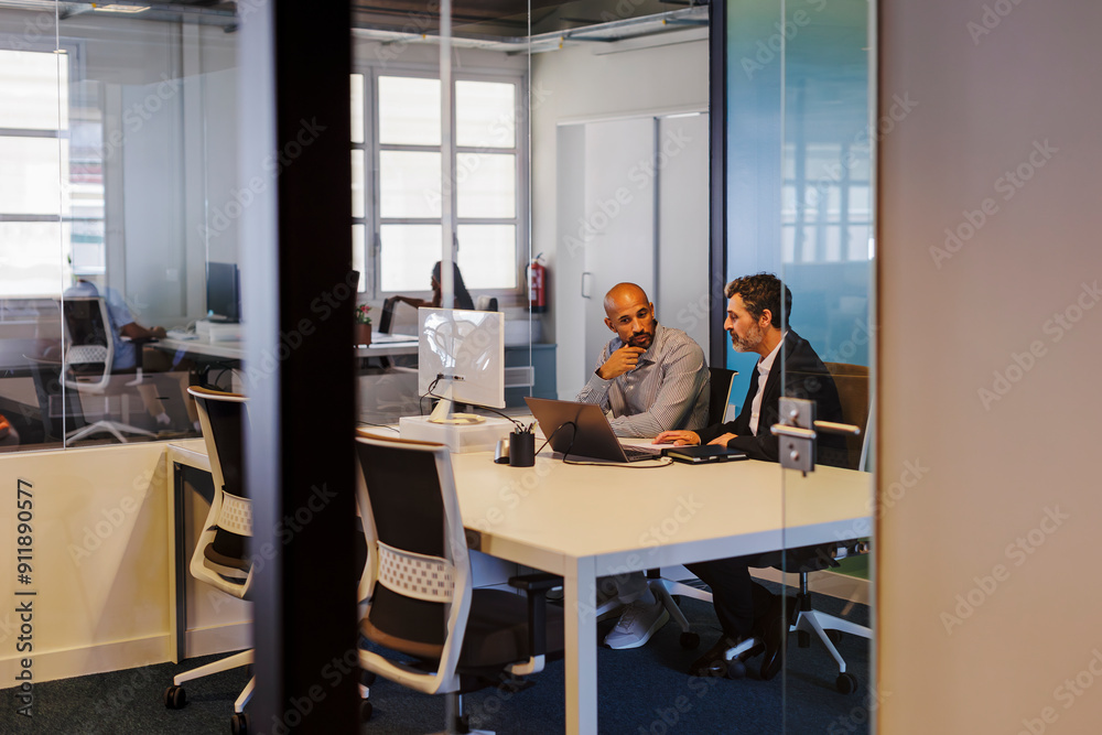 Businessmen discussing work in modern office Businessmen discussing work in modern office