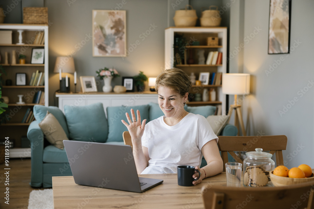 Adult woman waves during a video call Adult woman waves during a video call