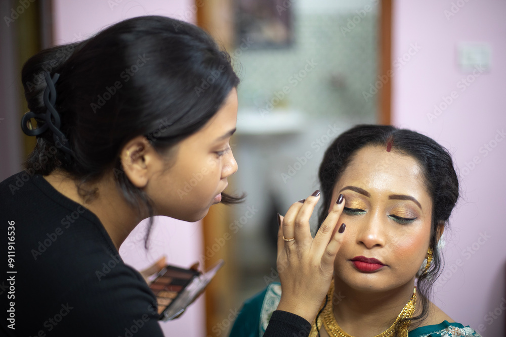 Indian woman taking makeup before attending a marriage programme Indian woman taking makeup before attending a marriage programme