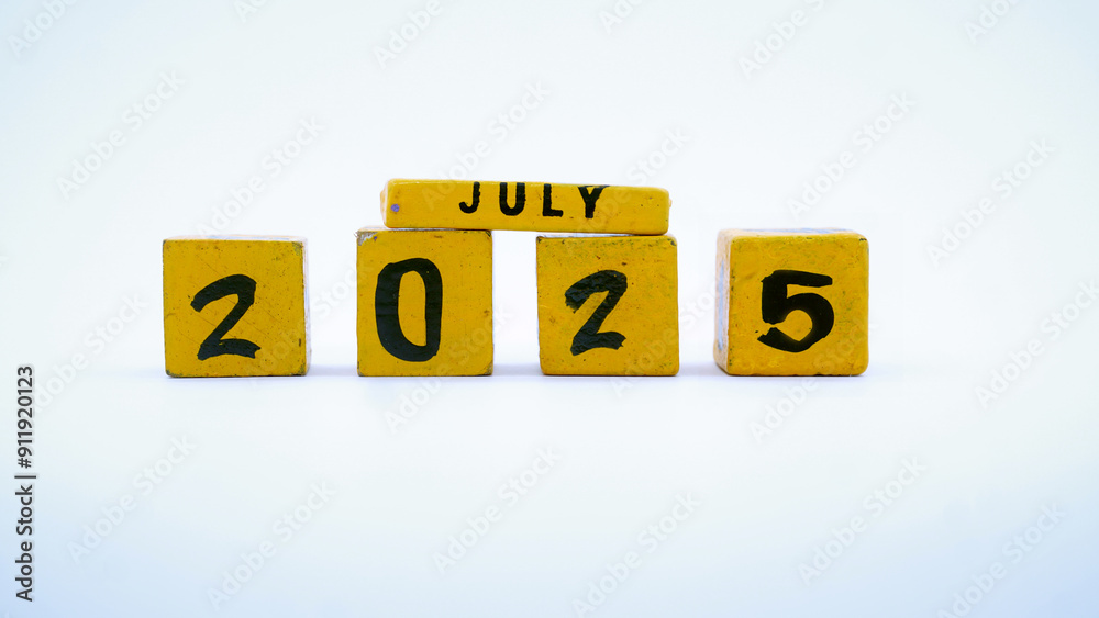 Wooden block calendar for July 2025. Yellow on a white background Wooden block calendar for July 2025. Yellow on a white background