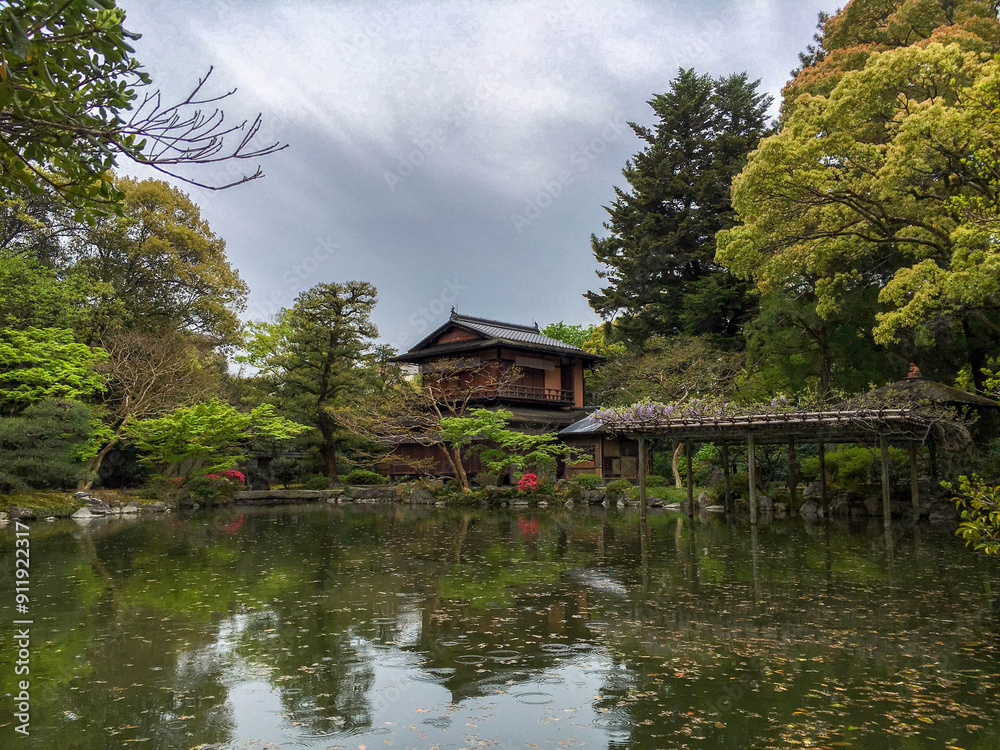 Traditional Japanese structure set among a beautiful Japanese garden and pond on a rainy day Traditional Japanese structure set among a beautiful Japanese garden and pond on a rainy day