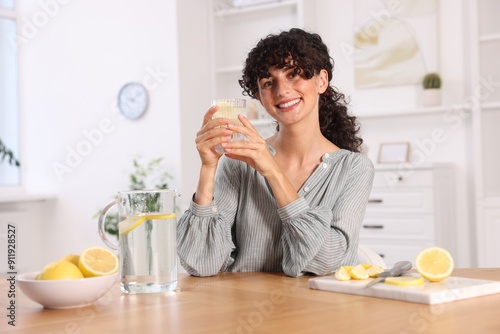 Woman with glass of lemon water indoors