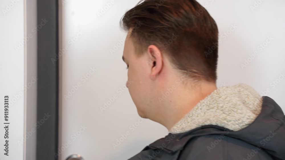 In a minimalist and uncluttered environment, a man stands wearing casual clothing, showing a thoughtful expression In a minimalist and uncluttered environment, a man stands wearing casual clothing, showing a thoughtful expression