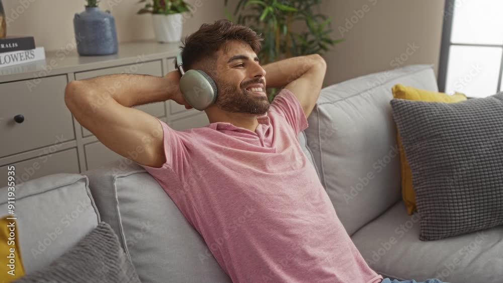 Young man relaxing with headphones on a couch in a cozy living room with plants and cushions Young man relaxing with headphones on a couch in a cozy living room with plants and cushions