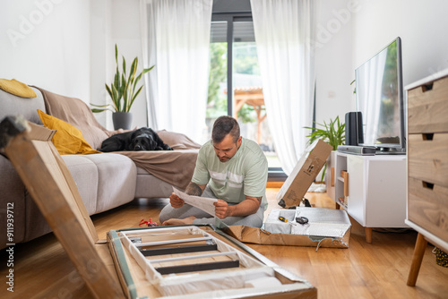 Focused man reading instructions assembling furniture photo