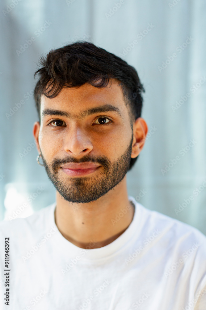 Man in white t-shirt in studio looking at camera. Man in white t-shirt in studio looking at camera.