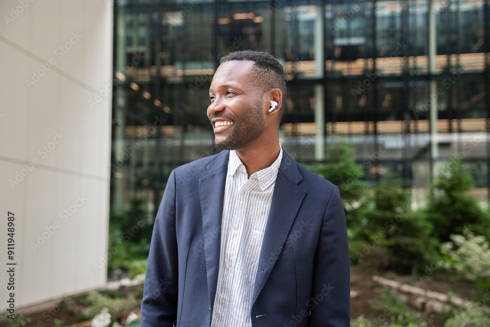 Businessman Smiling With Earbuds Outside Office Businessman Smiling With Earbuds Outside Office