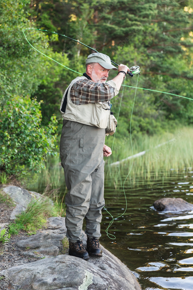 Fisherman Standing in Lake Amidst Scenic Wilderness Fisherman Standing in Lake Amidst Scenic Wilderness