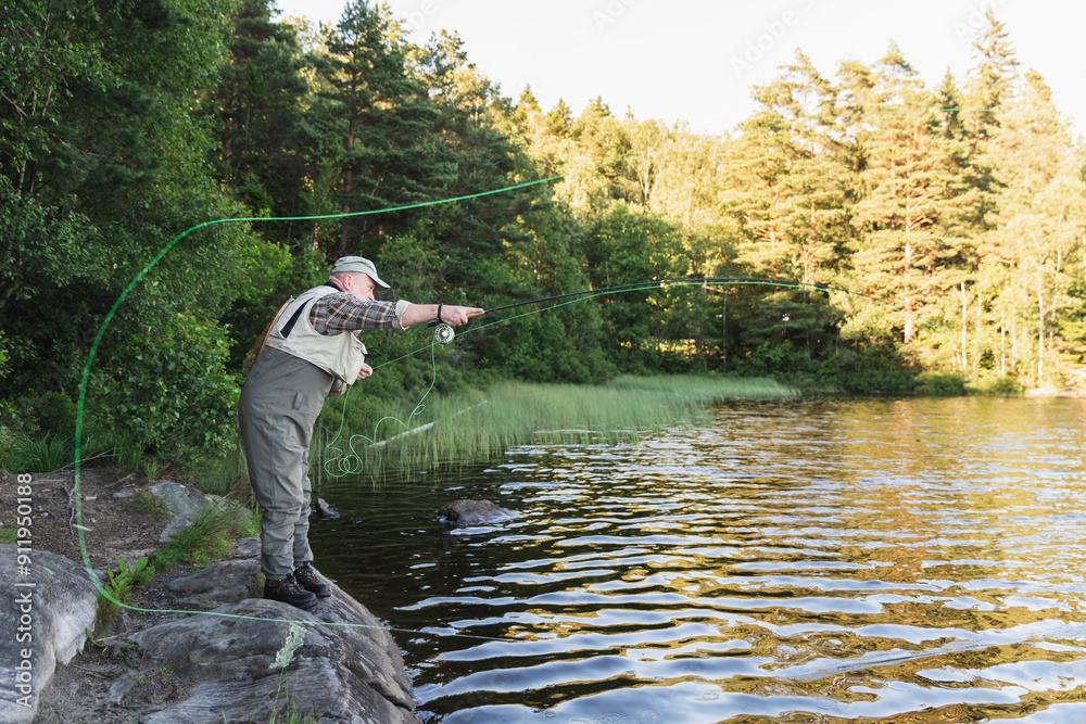 Fisherman Standing in Lake Amidst Scenic Wilderness Fisherman Standing in Lake Amidst Scenic Wilderness