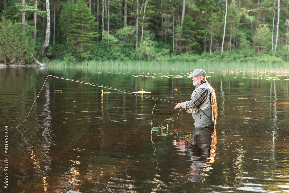 Fisherman Standing in Lake Amidst Scenic Wilderness Fisherman Standing in Lake Amidst Scenic Wilderness