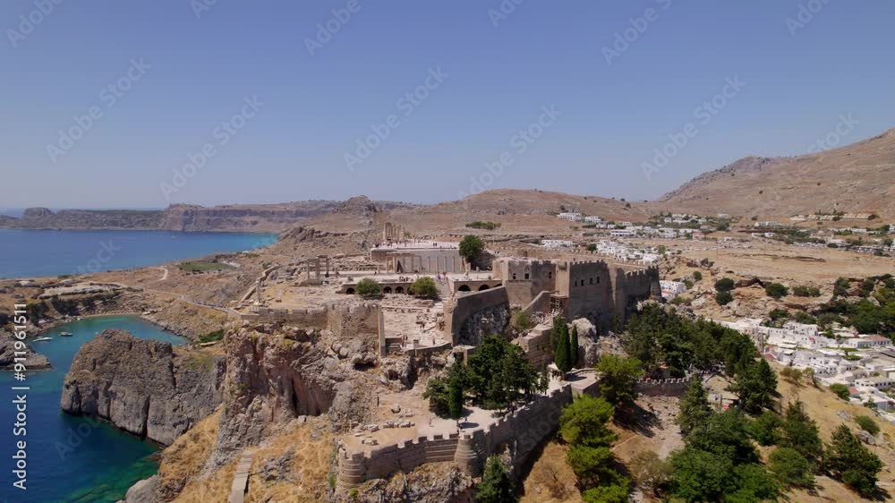 Pullback shot of Lindos' Medieval Castle high on a peak with scenic views. Pullback shot of Lindos' Medieval Castle high on a peak with scenic views.
