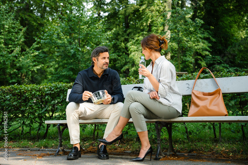 Man and woman eating lunch outdoors photo