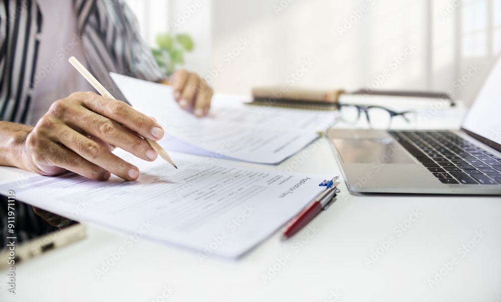 Asian man checking business documents using laptop working at home searching information for start own business, concept for working at home, start new business Asian man checking business documents using laptop working at home searching information for start own business, concept for working at home, start new business
