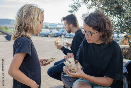 Parents and children eating street food outdoors photo