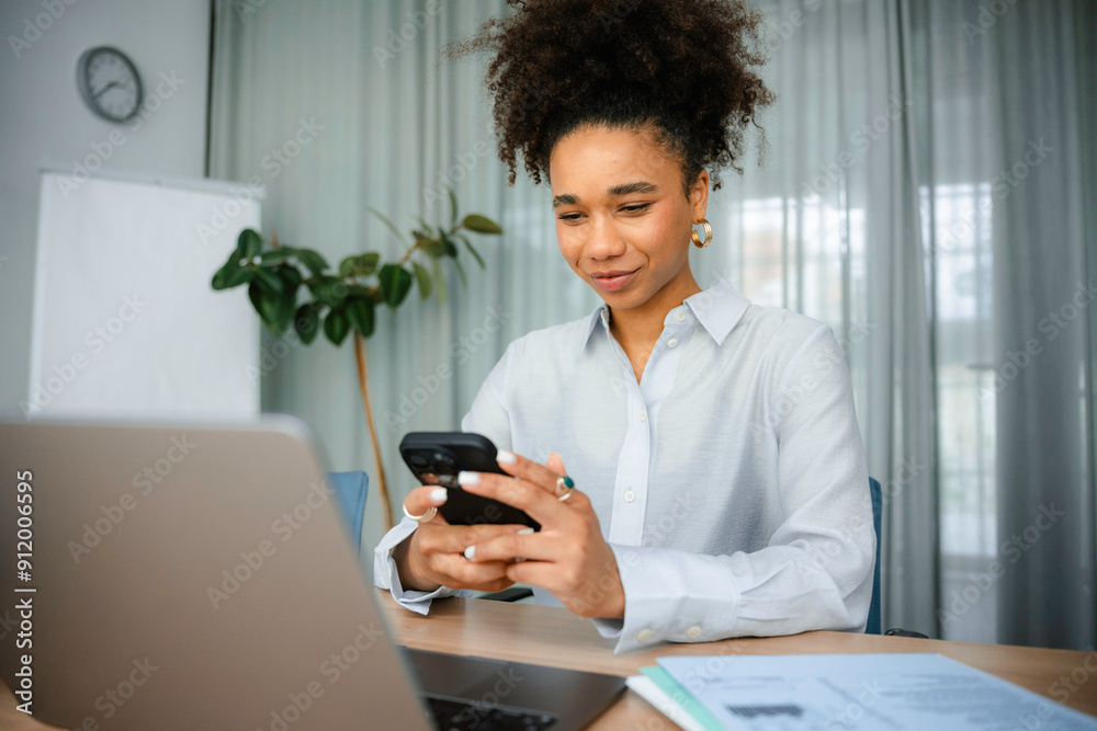 A woman uses a mobile phone in the office A woman uses a mobile phone in the office