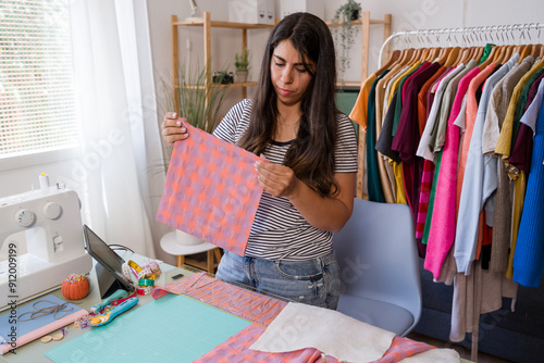 Fashion designer holding fabric in small business dressmaking atelier