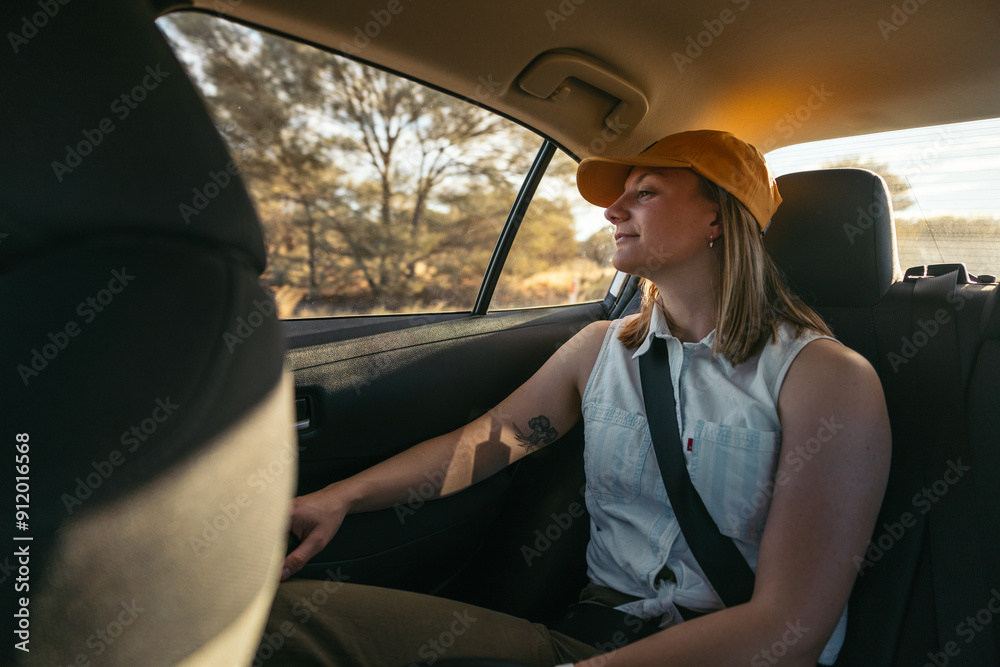 Young woman sitting in the backseat of a car looking out the window Young woman sitting in the backseat of a car looking out the window
