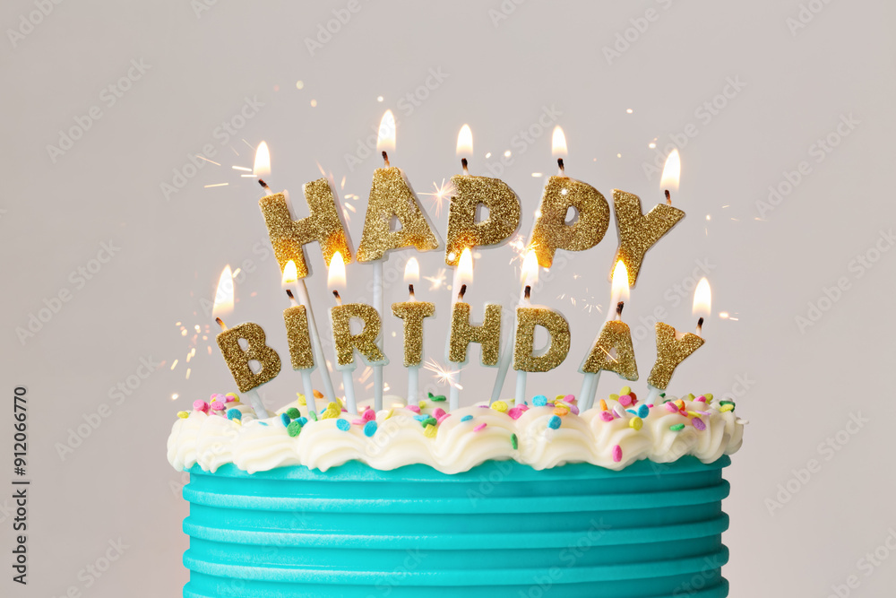 Happy birthday cake candles on a decorated birthday cake