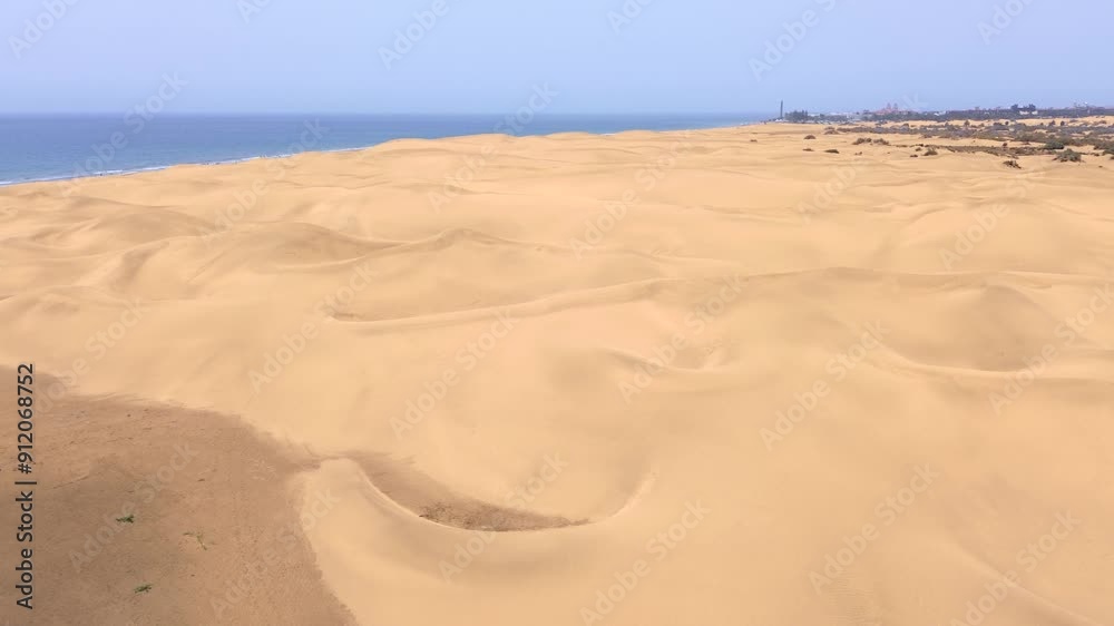 Sand dunes desert against seascape in Maspalomas Gran Canaria deserts near seashore. Aerial drone view of tourists walking thorugh the dunes of Maspalomas in Gran Canaria during a windy day. Sand dunes desert against seascape in Maspalomas Gran Canaria deserts near seashore. Aerial drone view of tourists walking thorugh the dunes of Maspalomas in Gran Canaria during a windy day.