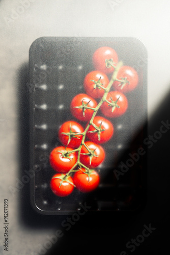 Red tomatoes in platic container photo