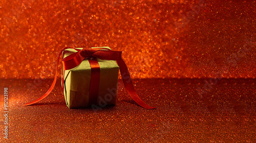 Gift with a red ribbon on a red background with sparkles. Banner. St. Valentine's Day. Christmas. New Year. Birthday. Present