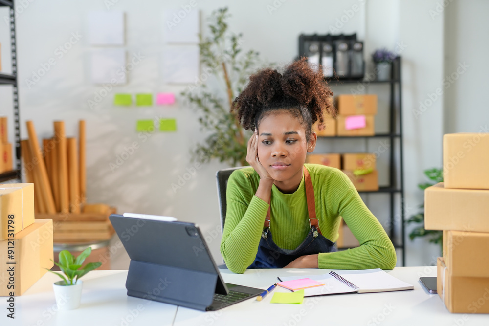 Young entrepreneur is experiencing stress while managing her online business from her warehouse Young entrepreneur is experiencing stress while managing her online business from her warehouse