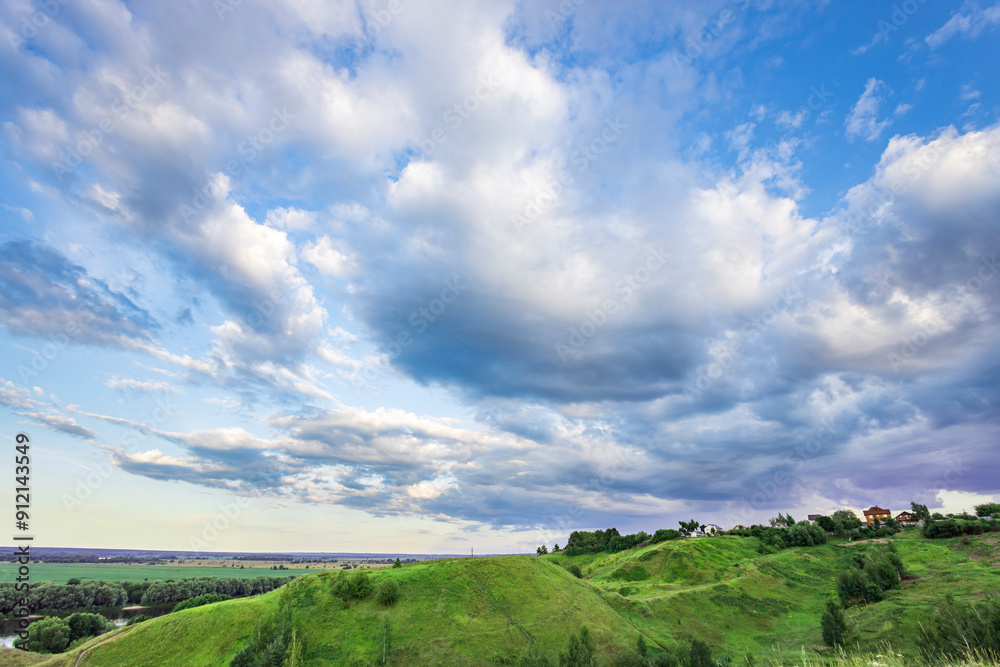 Fototapeta premium A cloudy sky with a hill in the background