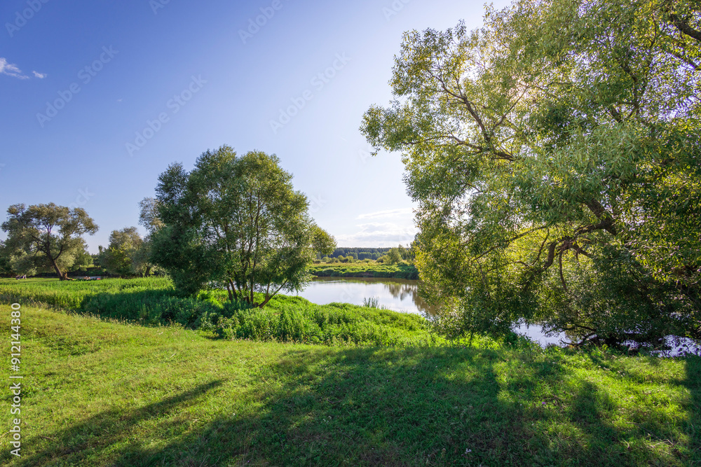A beautiful green field with a river running through it A beautiful green field with a river running through it