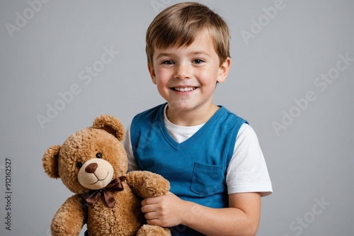 happy Boy holding and watching his teddy bear