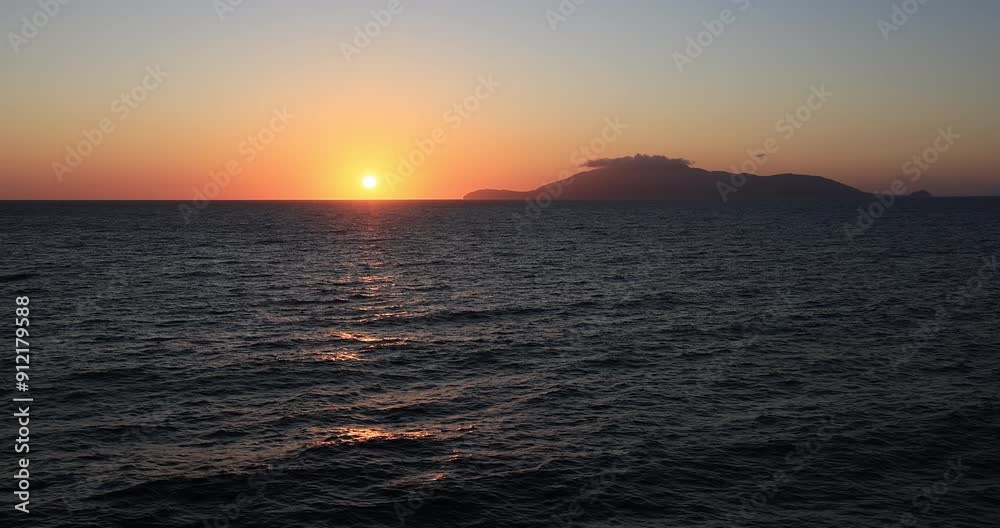 Mediterranean Sea Ocean Italy orange yellow sunset ship. Sunset Mediterranean Sea off shore Italian coast. Bright red and orange colors on ocean water. Surf and waves water surface. Cruise ship. Mediterranean Sea Ocean Italy orange yellow sunset ship. Sunset Mediterranean Sea off shore Italian coast. Bright red and orange colors on ocean water. Surf and waves water surface. Cruise ship.