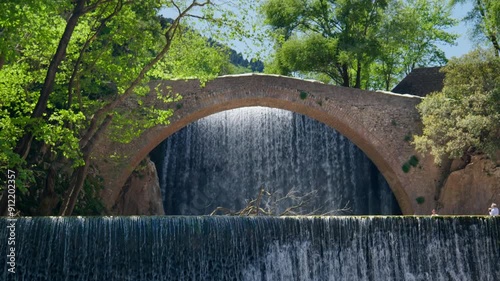 Stone Arch Bridge Palaiokarya Greece waterfall slow motion windy day photo