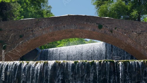 Historical Stone Arch Bridge Palaiokarya waterfall slow motion dolly photo