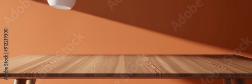 High-quality image of a smooth wooden table in a sunlit room with an orange wall, showcasing minimalist interior design.