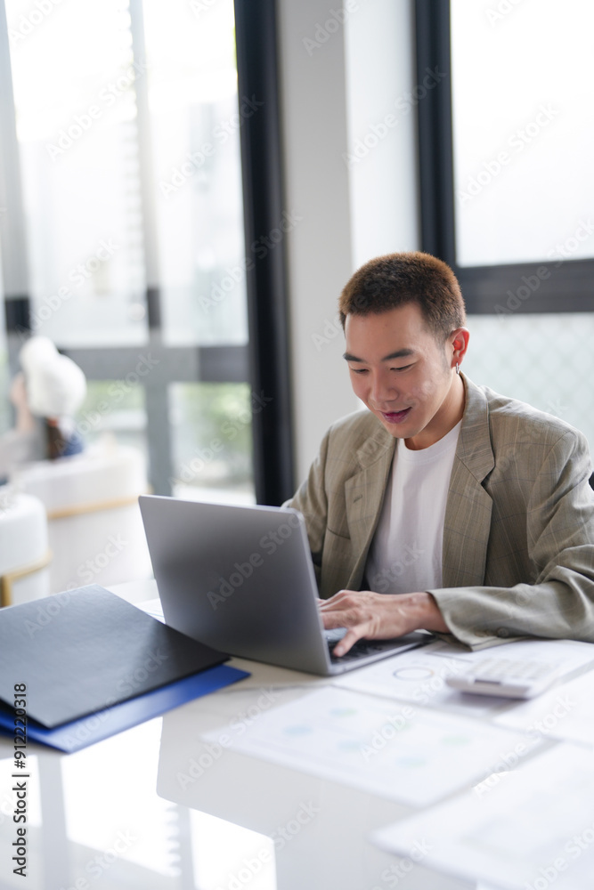 Attractive confident millennial Asian Business man using laptop computer and professional working investor start up project business planning in office. Attractive confident millennial Asian Business man using laptop computer and professional working investor start up project business planning in office.