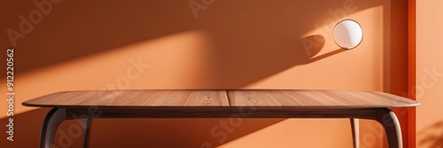 High-quality image of a smooth wooden table in a sunlit room with an orange wall, showcasing minimalist interior design.