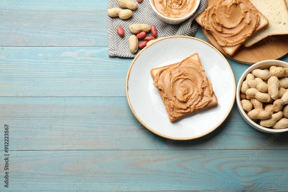 Tasty sandwiches with peanut butter and nuts on light blue wooden table, flat lay. Space for text Tasty sandwiches with peanut butter and nuts on light blue wooden table, flat lay. Space for text